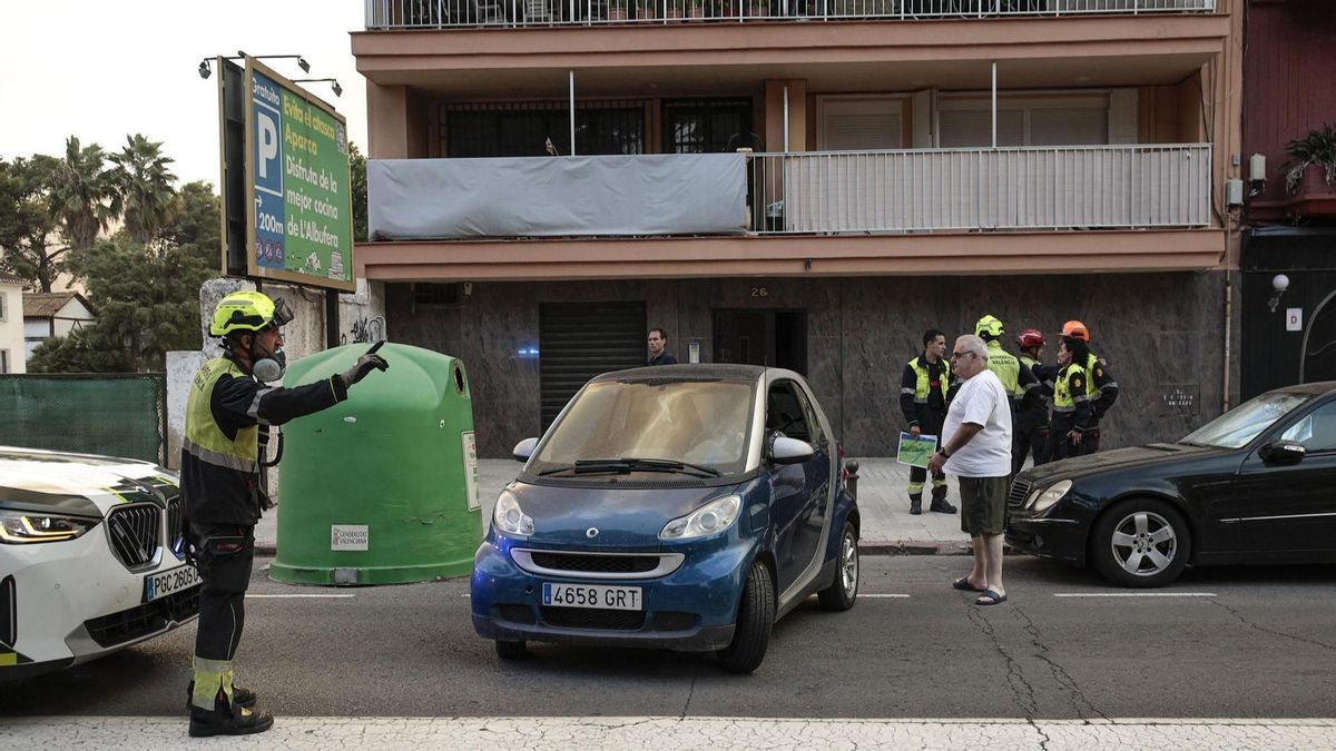 Un bomber dóna indicacions a uns veïns durant l'evacuació del poble del Saler, a València.