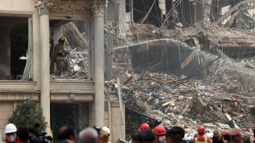Un grupo de rescatistas trabaja entre los escombros de un edificio que fue atacado por Estados Unidos e Israel esta mañana en el barrio de Andarzgu, en el noreste de Teherán.