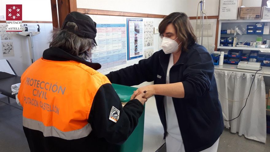 Una voluntaria de Protección Civil entrega las vacunas en un centro sanitario.
