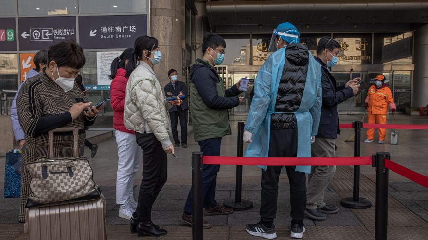 Un hombre con mascarilla muestra su código de salud mientras va a realizar una prueba COVID-19 fuera de la estación de tren Beijing Oeste en Pekín, China.EFE/EPA/ROMAN PILIPEY