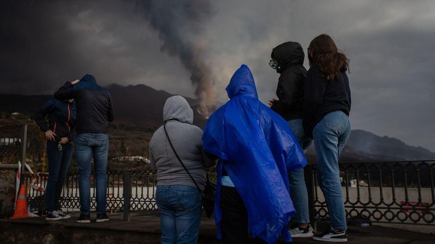 Varias personas observan la erupción bajo la lluvia en el mirador de Tajuya
