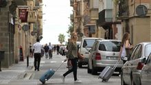 Una imagen ya habitual: turistas con maleta en busca de su casa temporal.
