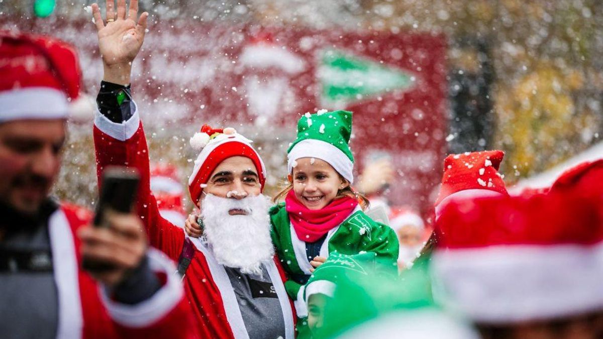Una niña junto a su padre en la carrera de Papá Noel