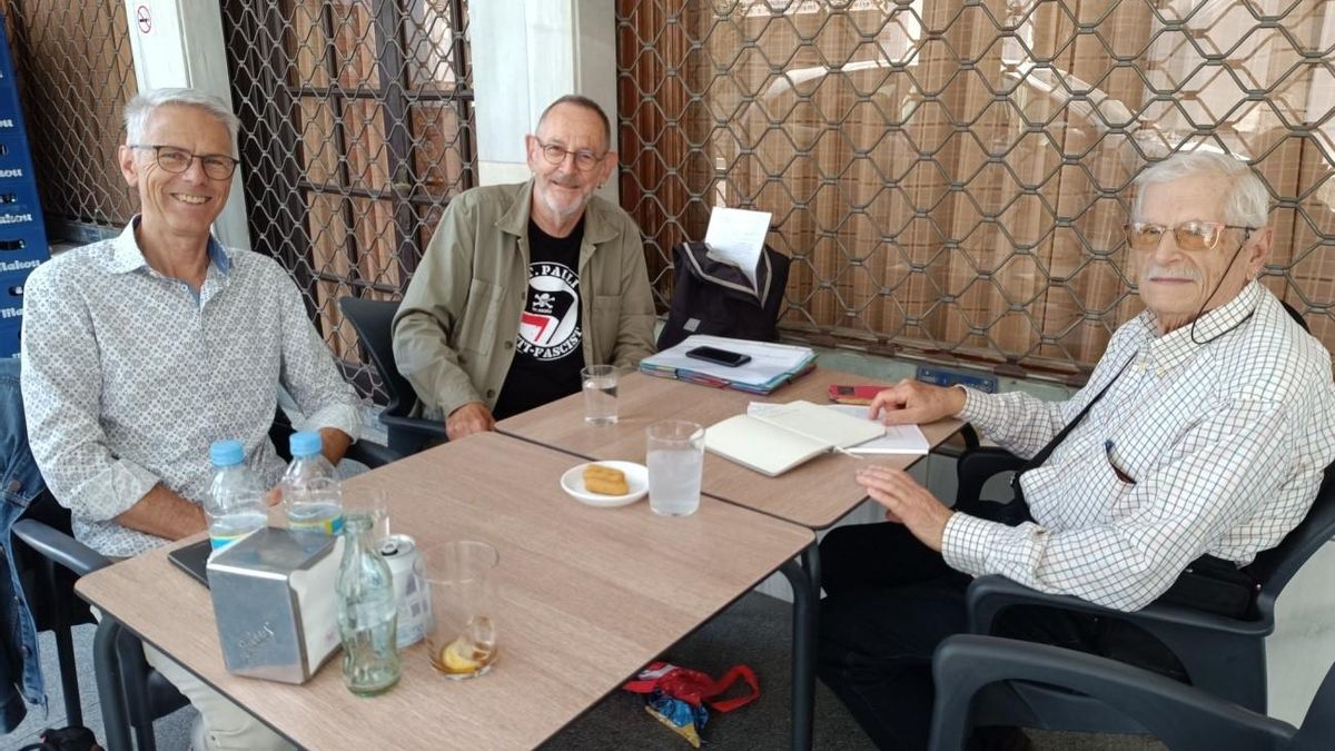 Los profesores Josef Brágger, Alfred Saam y Francisco Moreno intercambiando documentación.