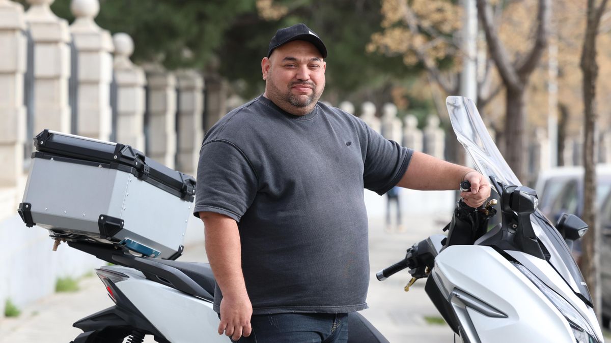 Jamer Torrado, exrepartidor de Glovo en Madrid, junto a su motocicleta.