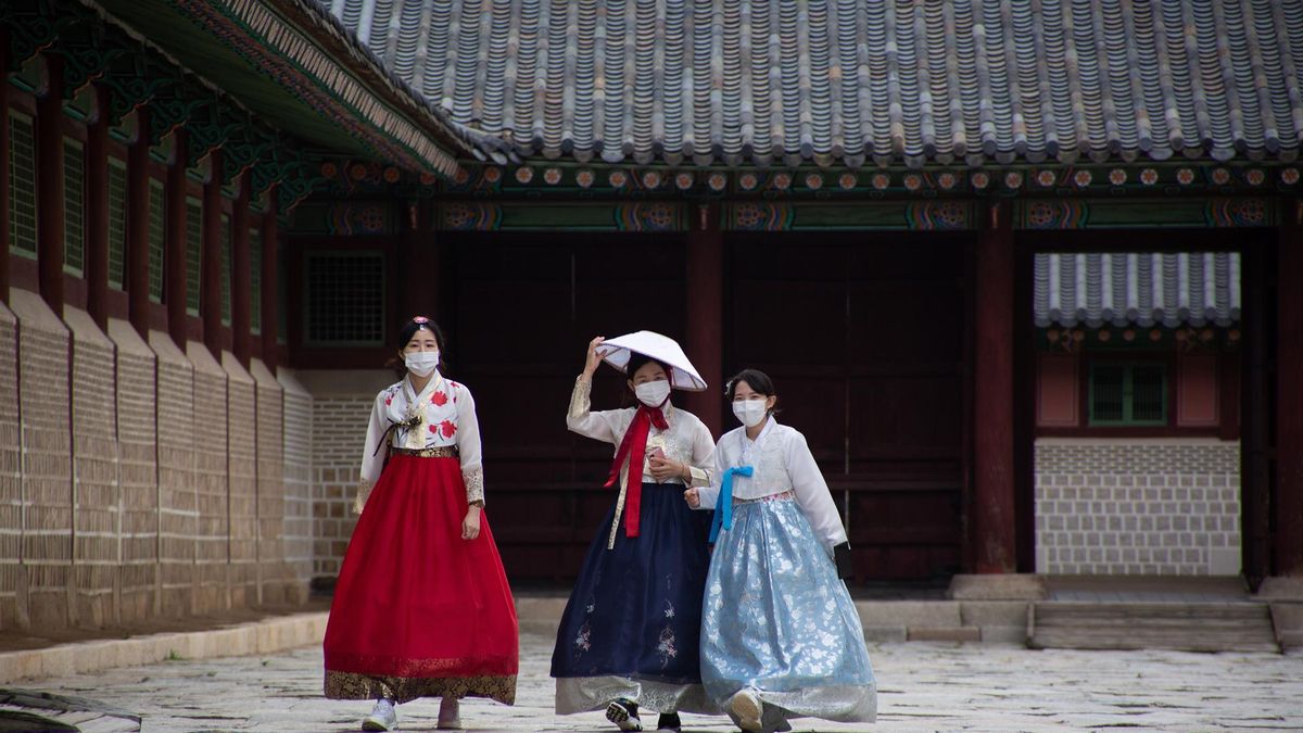 Visitors wearing face masks and traditional clothes walk at the Gyeongbokgung Palace in Seoul, South Korea, 11 October 2021. (Corea del Sur, Seúl)