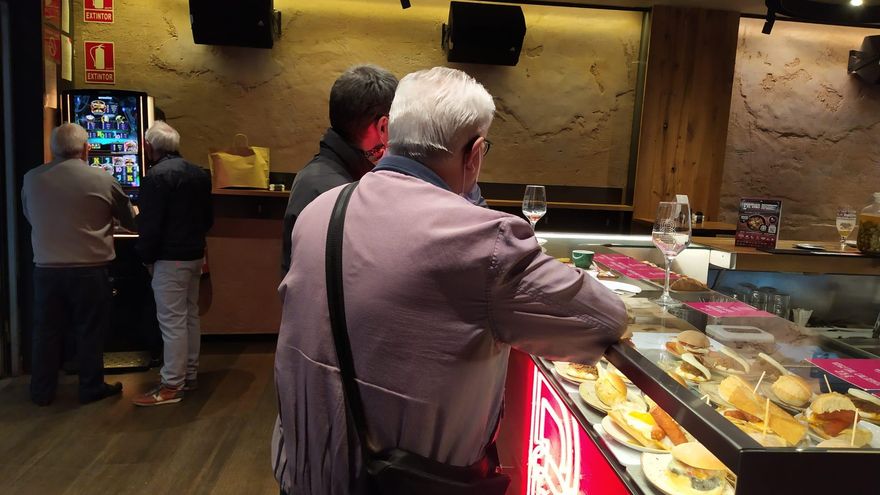 Tres personas en una barra de un bar de Pamplona