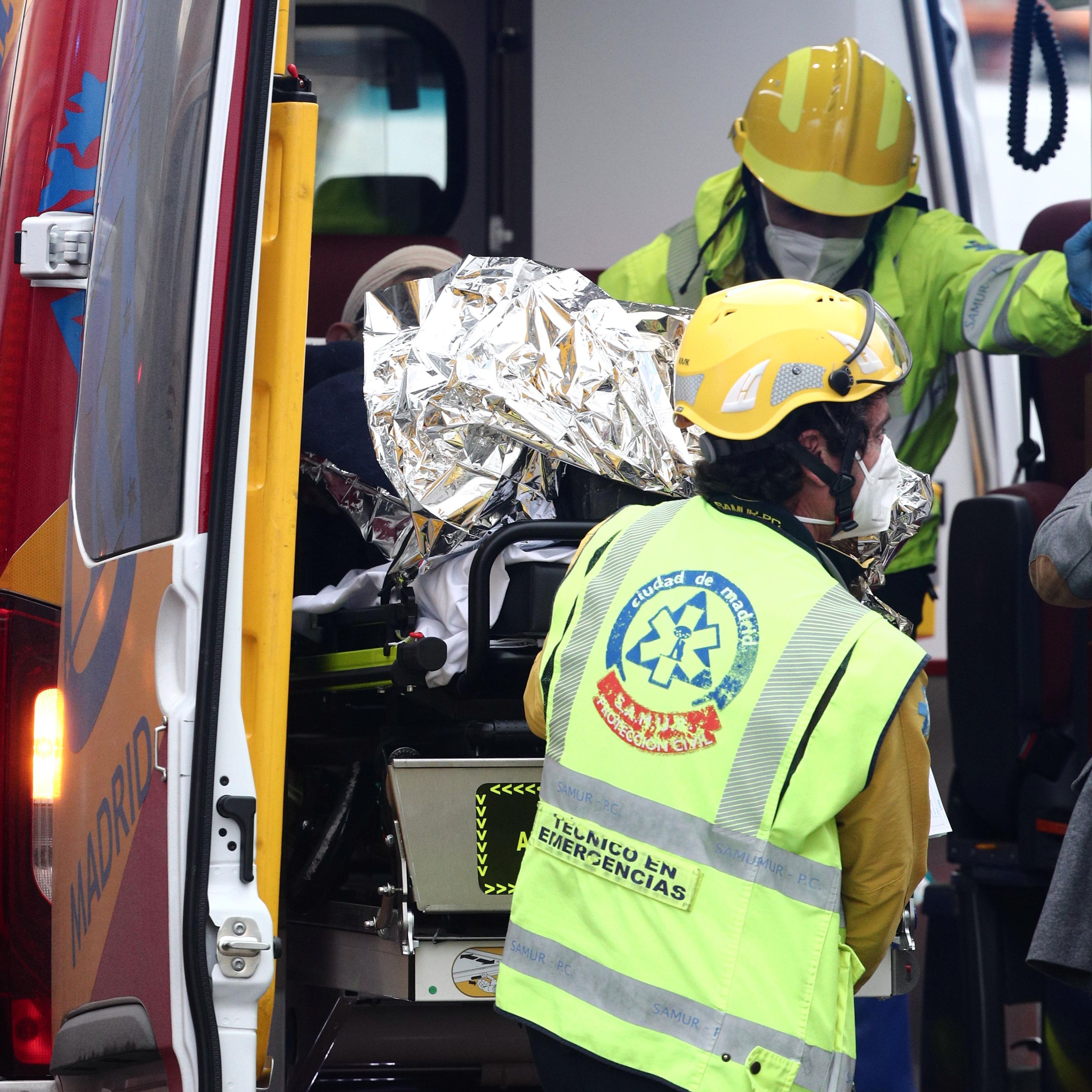 Varios trabajadores sanitarios introducen a un herido en una ambulancia momentos posteriores a la fuerte explosión registrada la calle Toledo.