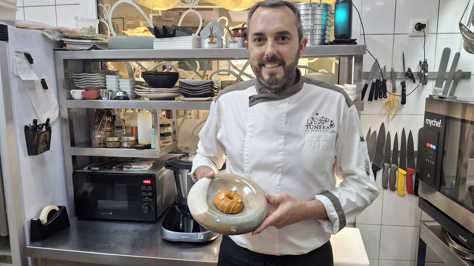 Manuel González, fundador de La Tunera, posa en la cocina de su restaurante de Telde con un dónut de sancocho rebozado con crema de gofio.