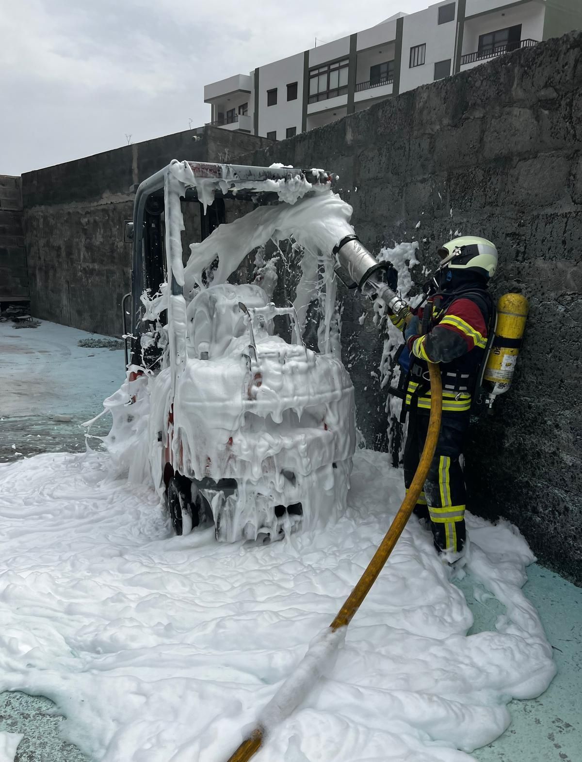 Un bombero apagando el incendio  del montacargas.