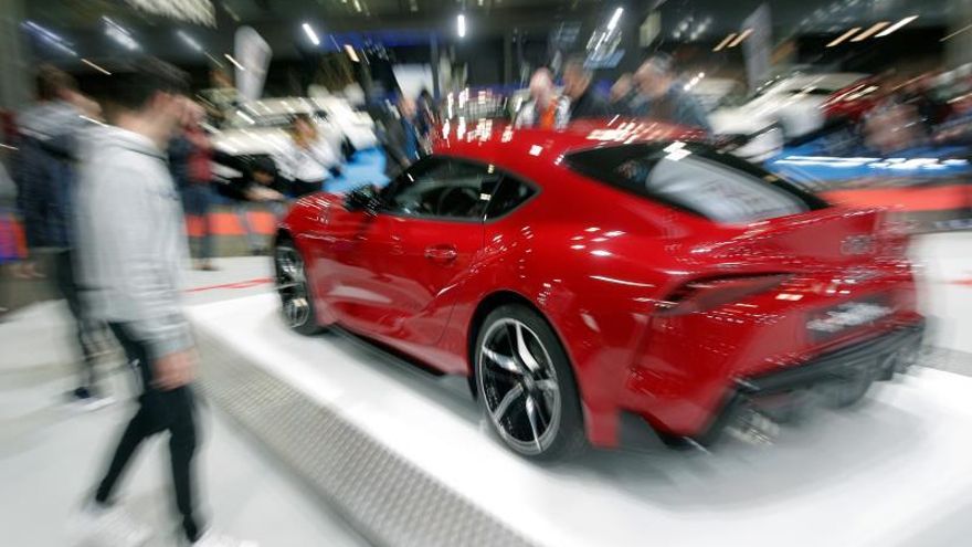 Varias personas contemplan un vehículo en la Feria del Automóvil de Valencia.