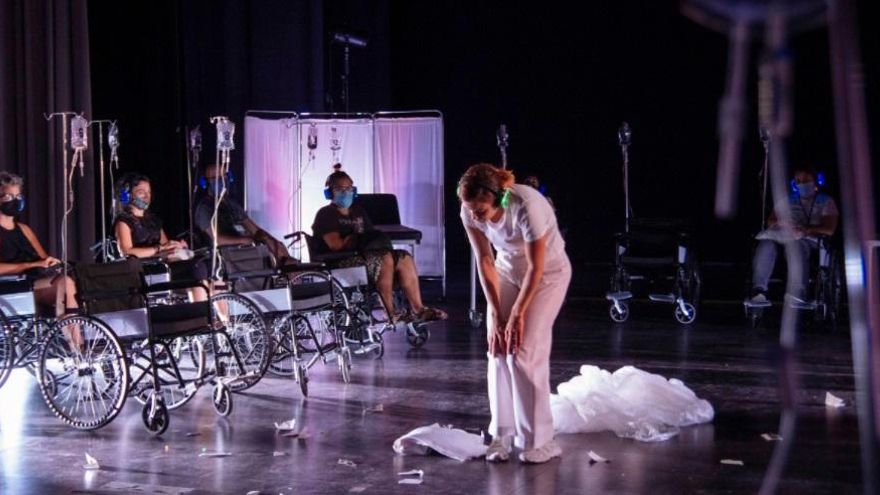 Una actriz, vestida de médico baila frente a los espectadores