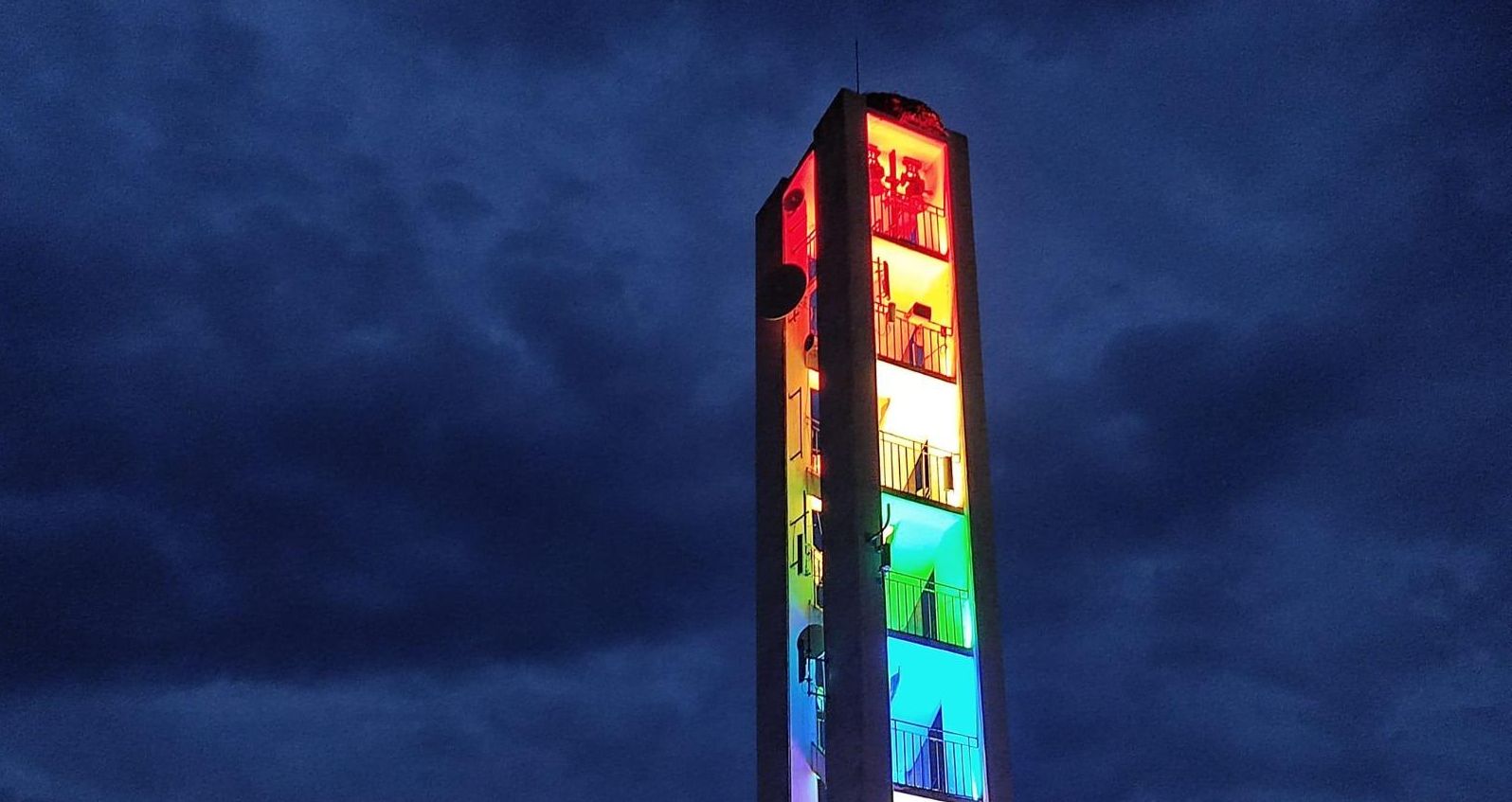 Torre de la iglesia de la entidad local menor de Vivares (Badajoz) con los colores de la bandera LGTBI