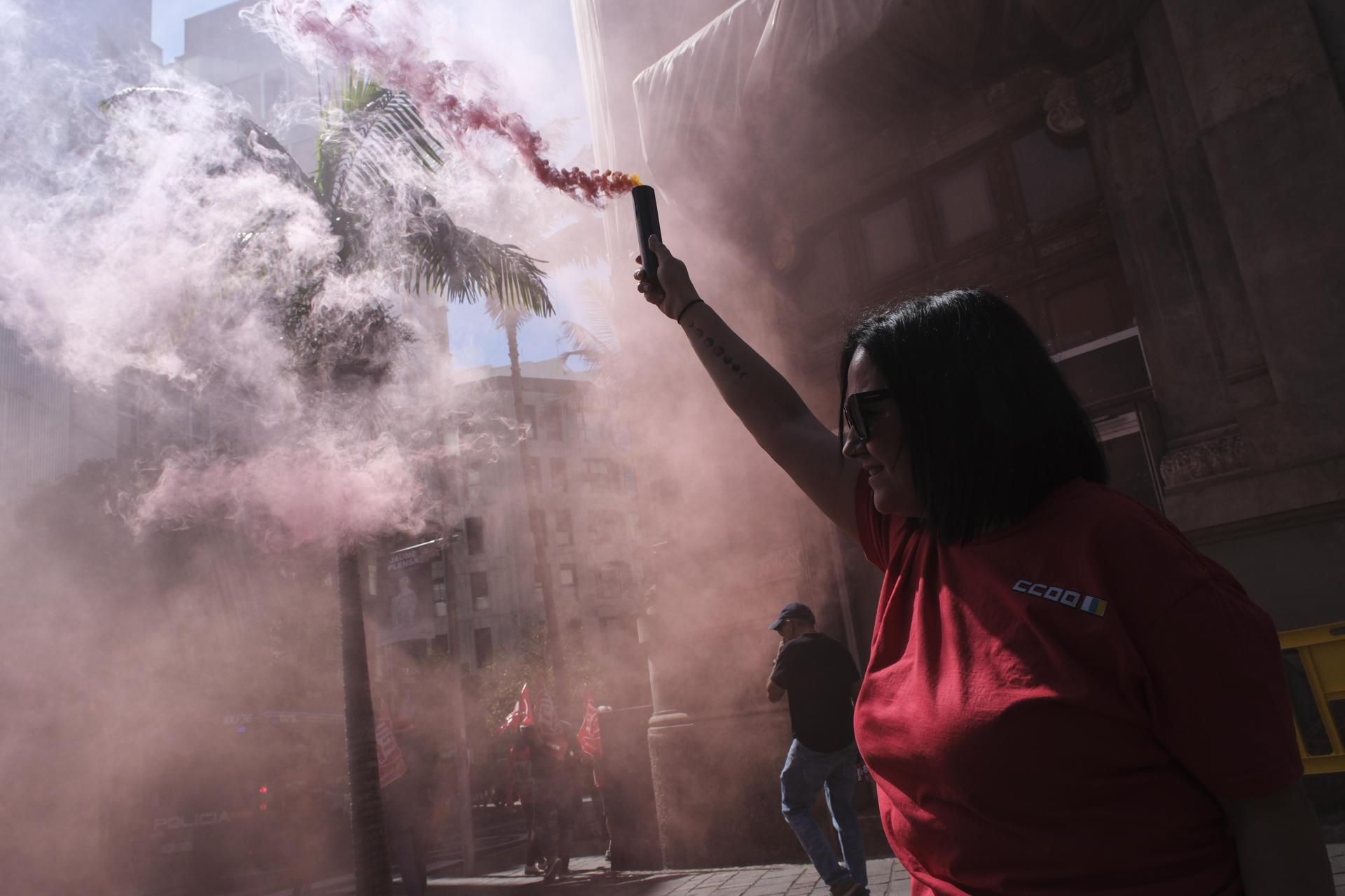 Una mujer sujeta una bengala en la manifestación de este viernes por las calles de Santa Cruz de Tenerife, con motivo del Primero de Mayo, Día Internacional del Trabajador.