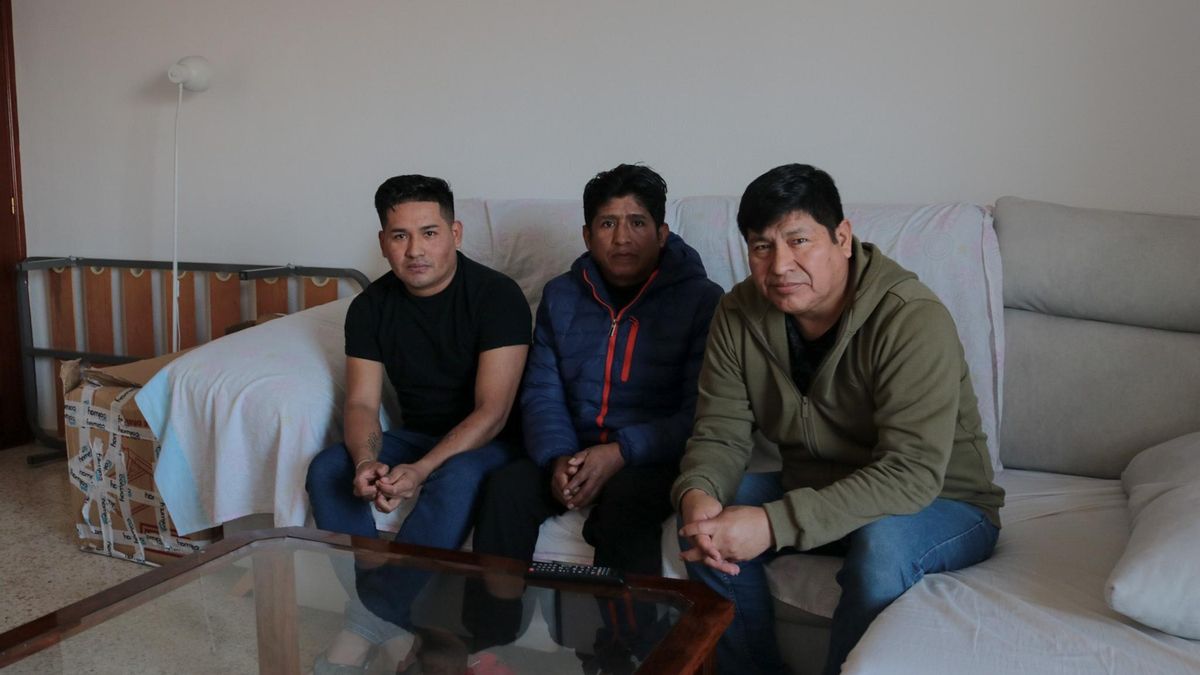 Denis Merino, Edy Quispe y Juan Vargas, de izq. a dcha., en el piso donde viven en Sevilla tras ser captados por una subcontrata portuguesa para trabajar en el sector energético, con una caja enviada por parte de Colway Industrial en el fondo.