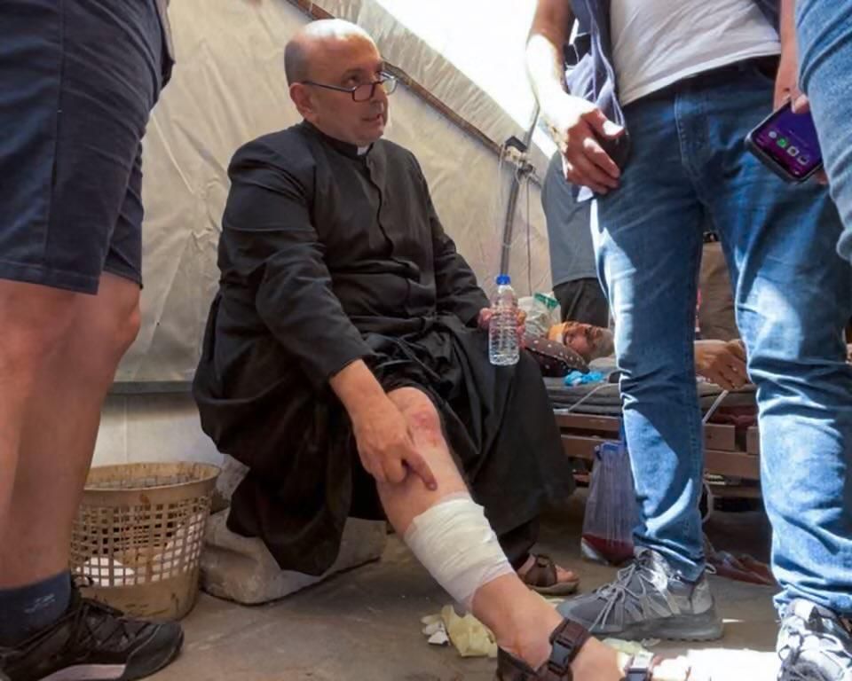 El padre Gabriel Romanellki muestra su herida en la pierna tras el ataque a la iglesia en Gaza.