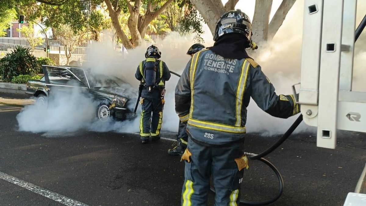 Efectivos de Bomberos de Tenerife sofocan las llamas de un vehículo en la capital tinerfeña.