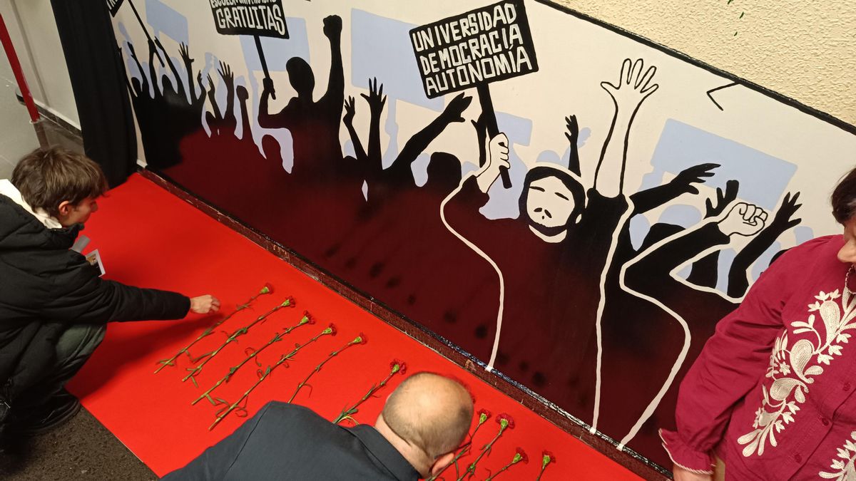 El momento en el que los asistentes han dejado los claveles a los pies del mural