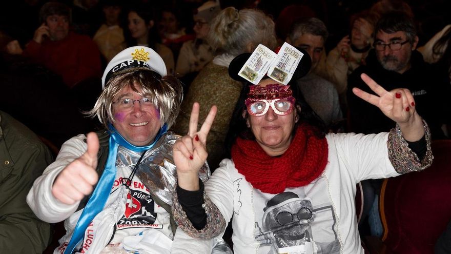 Dos personas disfrazadas esperan a que empiece el Sorteo Extraordinario de la Lotería de Navidad 2025