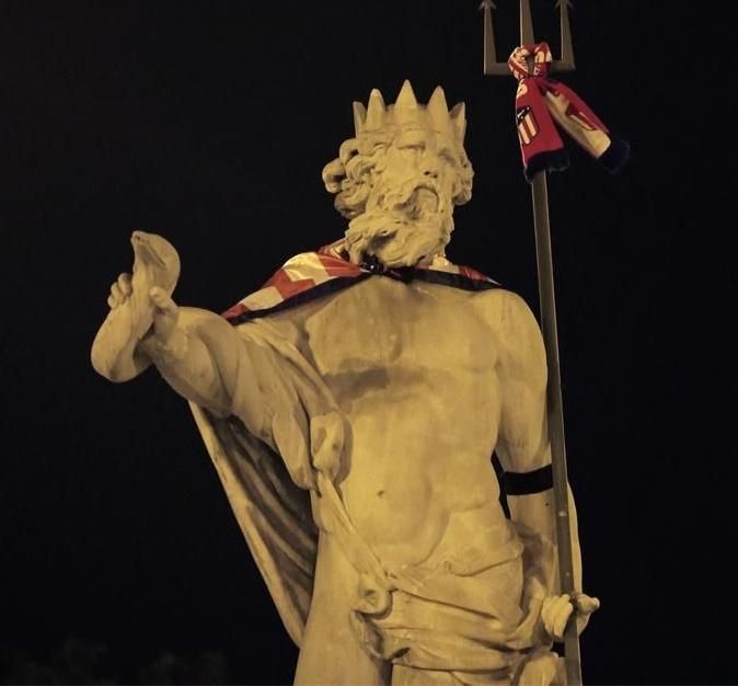 Escultura de Neptuno con los colores del Atlético y el brazalete negro en recuerdo al joven fallecido
