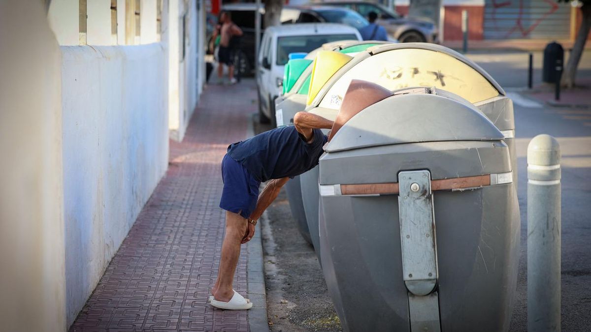 Uno de los 'clubbers' vomita detrás de un contenedor junto a una pista de fútbol donde juegan unos chavales.