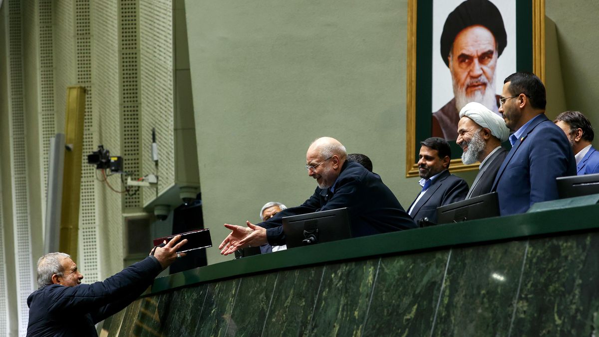 Imagen de diciembre de 2025 en la que el presidente iraní, Masoud Pezeshkian, entrega el presupuesto al presidente del Parlamento, Mohamed Ghalibaf. 