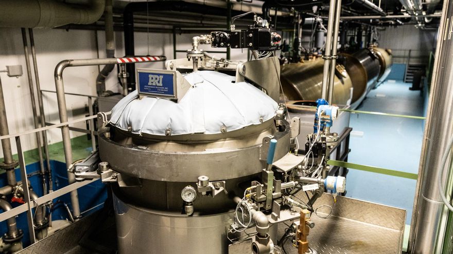 Planta de descontaminación de residuos. En primer plano, una instalación de digestión alcalina para tratar los restos sólidos. Al fondo, tres grandes depósitos sobre una "piscina" se usan para almacenar y descontaminar los residuos líquidos.