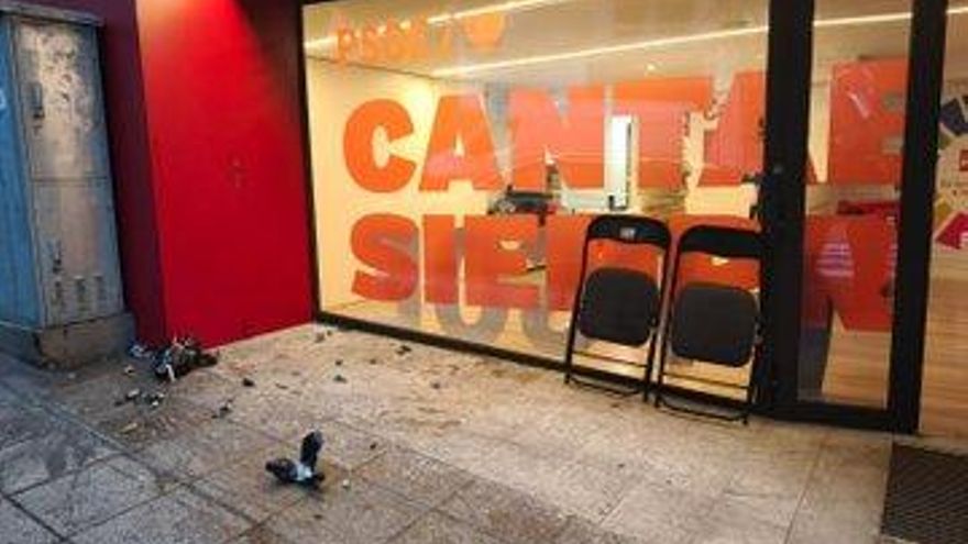 A hooded individual throws homemade devices inside the PSOE headquarters in Cantabria during an event on democratic memory