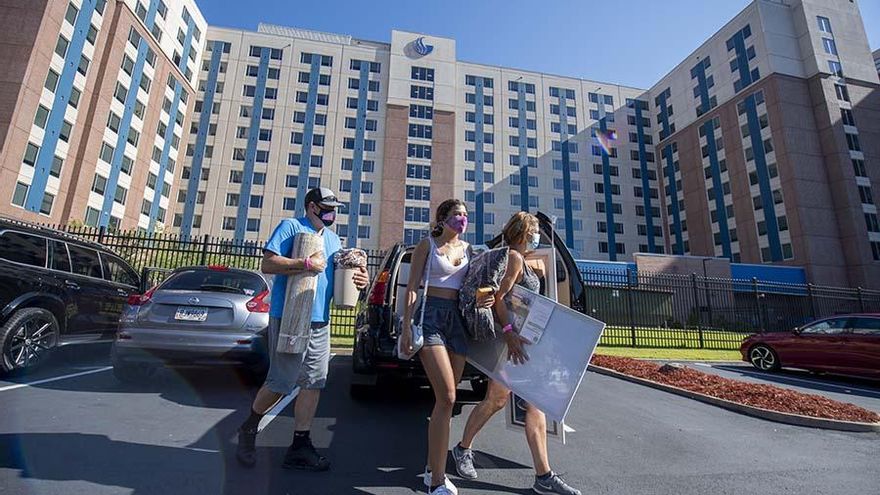 Sarah Kessler (c), estudiante de primer año, haciendo la mudanza a la residencia de la universidad con la ayuda de sus padres.