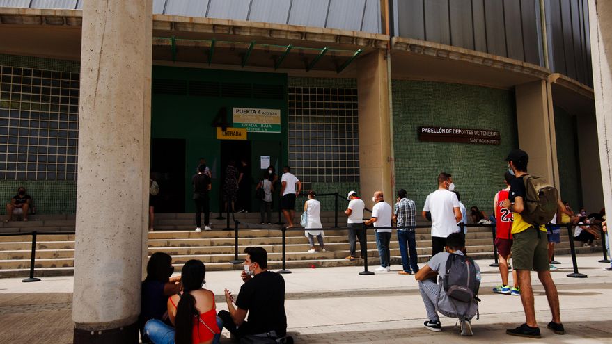 Varios jóvenes esperan sentados frente al Santiago Martín