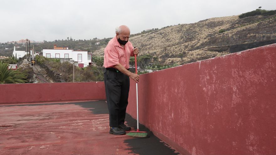 Julio barre de ceniza la azotea de su casa, a las afueras del núcleo urbano de Santa Cruz de La Palma.
