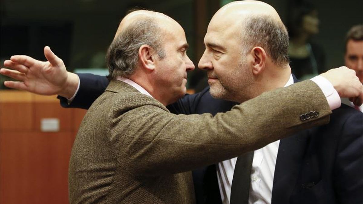 Guindos saluda a Pierre Moscovici.