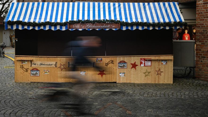 Un ciclista pasa junto a un puesto de un mercadillo cerrado en Landshut, Alemania.