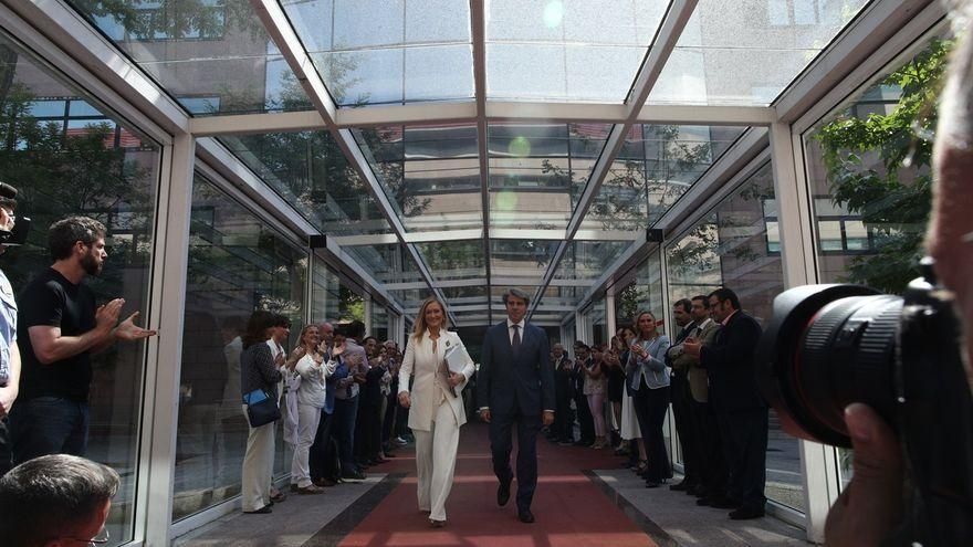 Cifuentes camina junto a Ángel Garrido y recibe los aplausos de los diputados del PP en la Asamblea de Madrid.