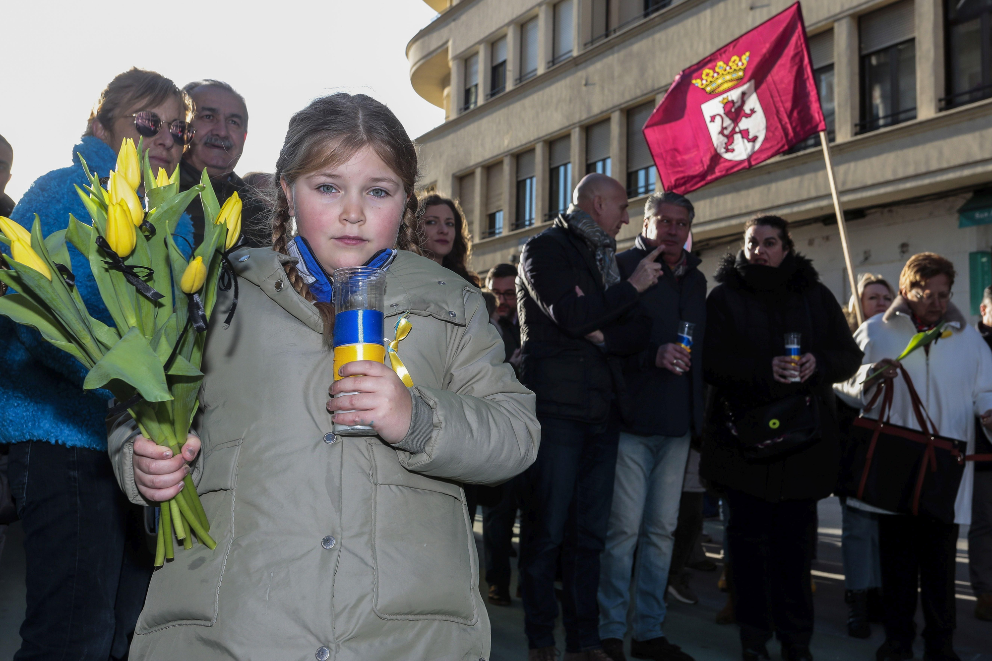 Tulipanes amarillos, velas y una bandera de León.
