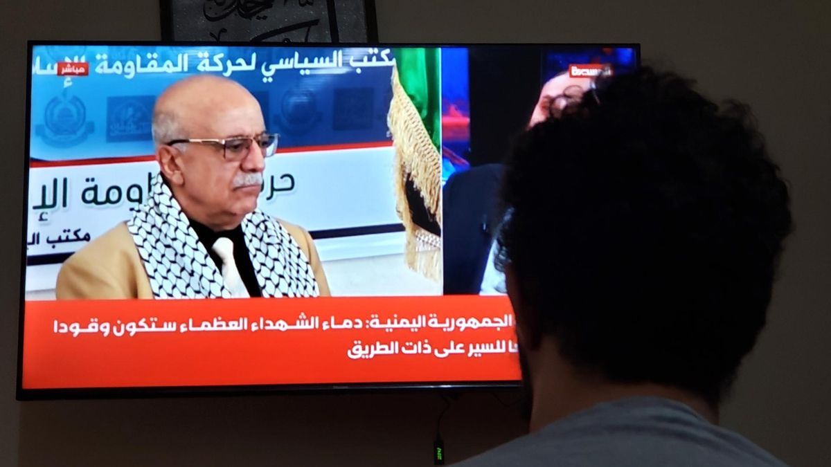 Un hombre observa imágenes del primer ministro hutí Ahlmed Al-Rahawi en la televisión en Saná, la capital de Yemen, este sábado.