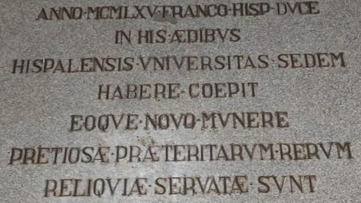 Placa presente en unos de los patios del Rectorado, cuya traducción del latín rezaría así: "En el año de 1965, siendo Franco caudillo de España, la Universidad Hispalense comenzó a tener su sede en este edificio y en su nueva función se conservaron los preciosos restos de su pasado".