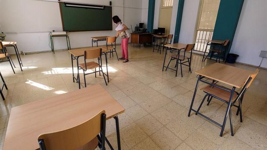 Una profesora preparado con la señalización correspondiente y las medidas de higiene para el alumnado. Efe/Ángel Medina G.