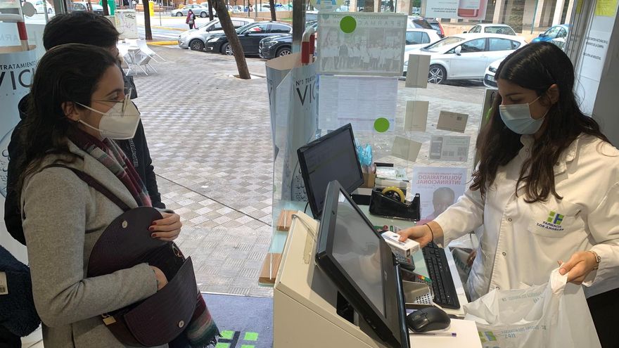 Varias personas compran test de antígenos en una farmacia de Dos Hermanas, Sevilla.