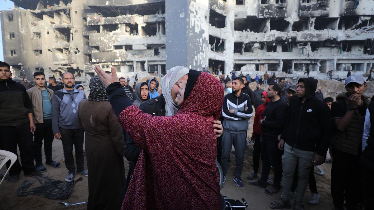 Una mujer llora mientras numerosas personas se congregan alrededor del hospital Al Shifa.