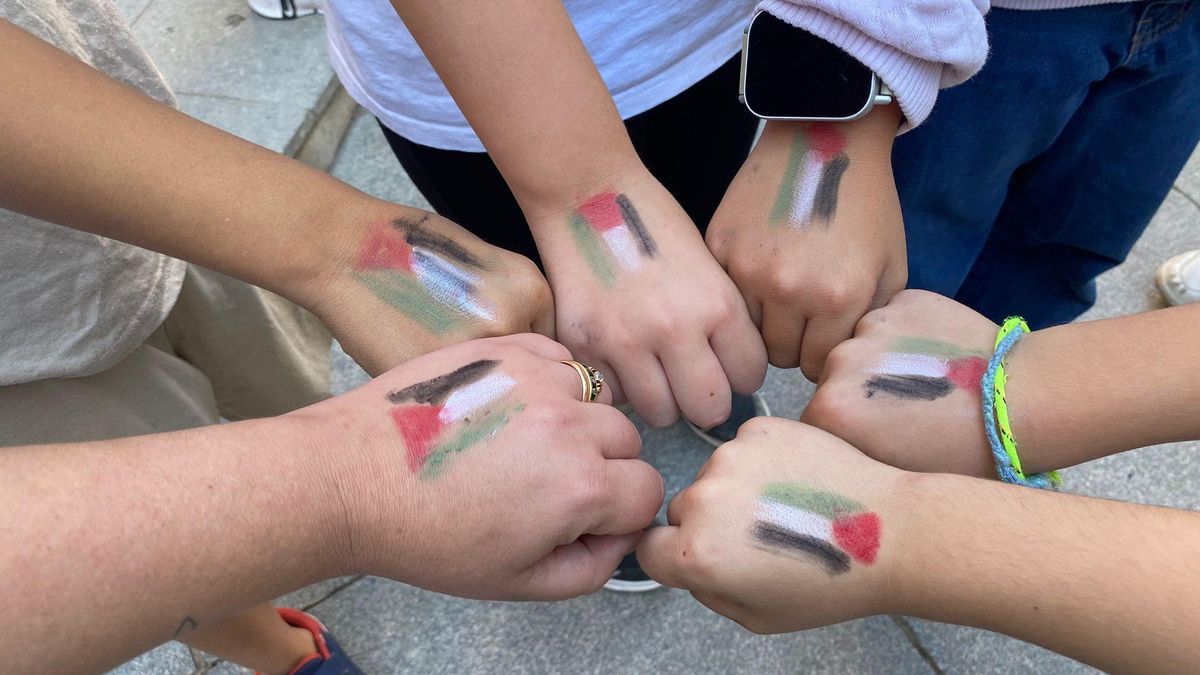 Banderas palestinas en las manos de algunos de los alumnos que participaron en la decoración