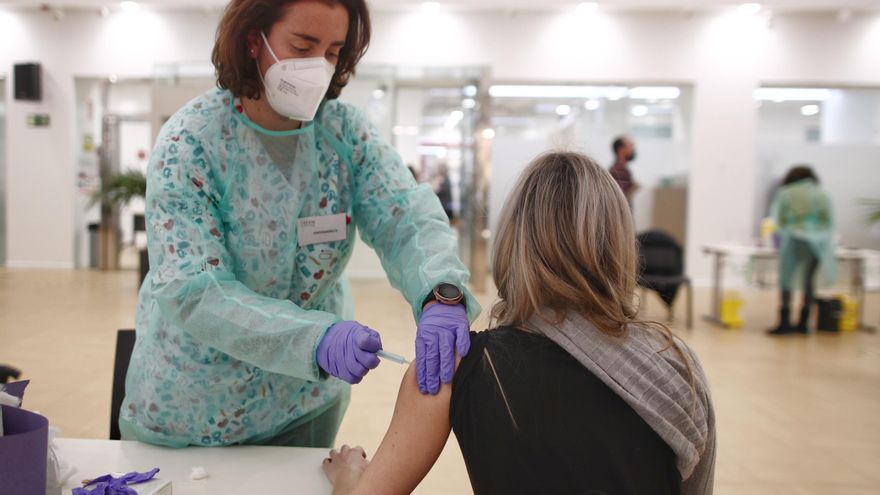 Una farmacéutica recibe la vacuna contra la COVID-19, en la sede del Colegio Oficial de Farmacéuticos de Madrid (COFM).