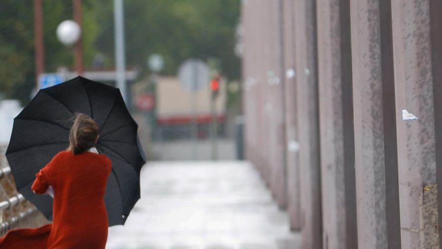Archivo - Imagen de archivo de viandante por el puente de San Telmo en Sevilla en una mañana de tormentas y lluvias.