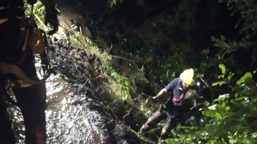 Un bombero  se descuelga para acceder al vehículo.