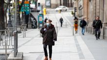Una mujer con mascarilla pasea por la calle de Alcalá durante el estado de alarma decretado por el Gobierno para combatir el coronavirus, en Madrid (España)
