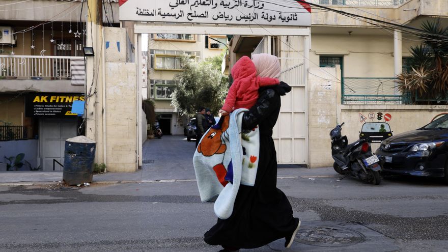 Una mujer carga a su hijo mientras huye de su hogar tras los ataques aéreos israelíes en Beirut, Líbano, el 9 de marzo de 2026. EFE/WAEL HAMZEH