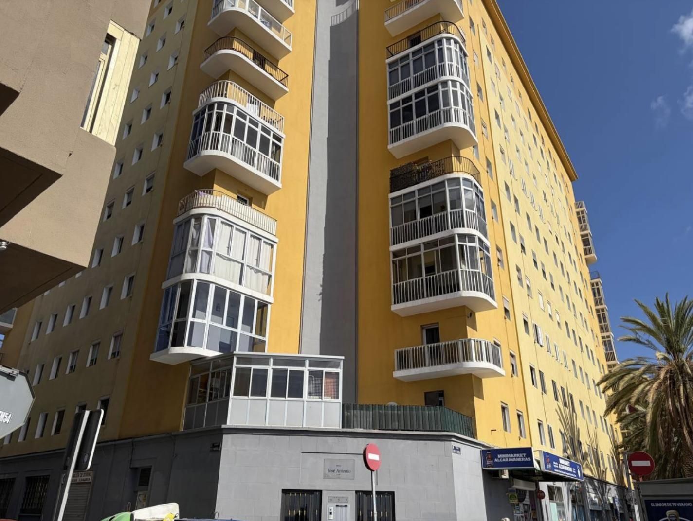 La fachada principal del edificio José Antonio con su placa y una perspectiva de sus dimensiones, las que en los sesenta lo condujeron a llevar el nombre de Casa del Coño.