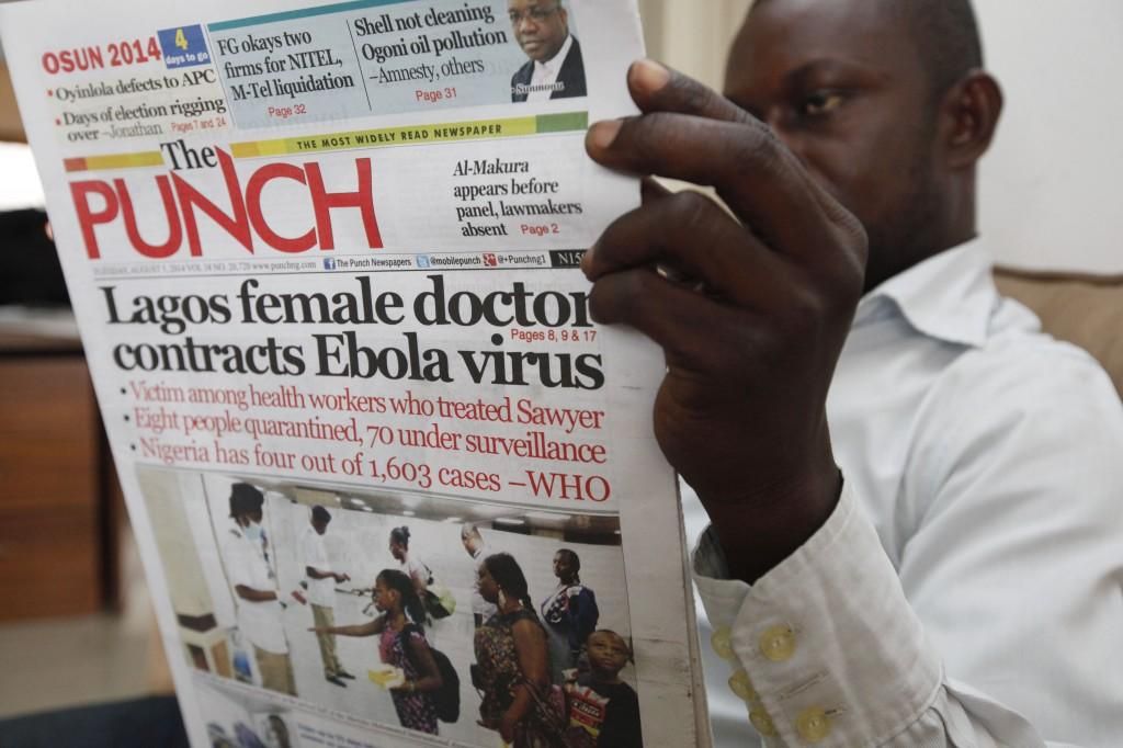 Un ciudadano lee un periódico que informa sobre la aparición del virus en Nigeria