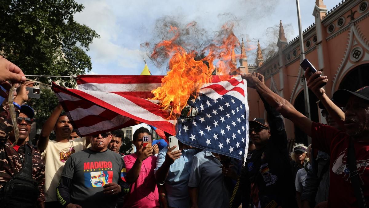 Partidarios de Nicolás Maduro queman una bandera de Estados Unidos durante una concentración cerca del palacio de Miraflores en Caracas (Venezuela).