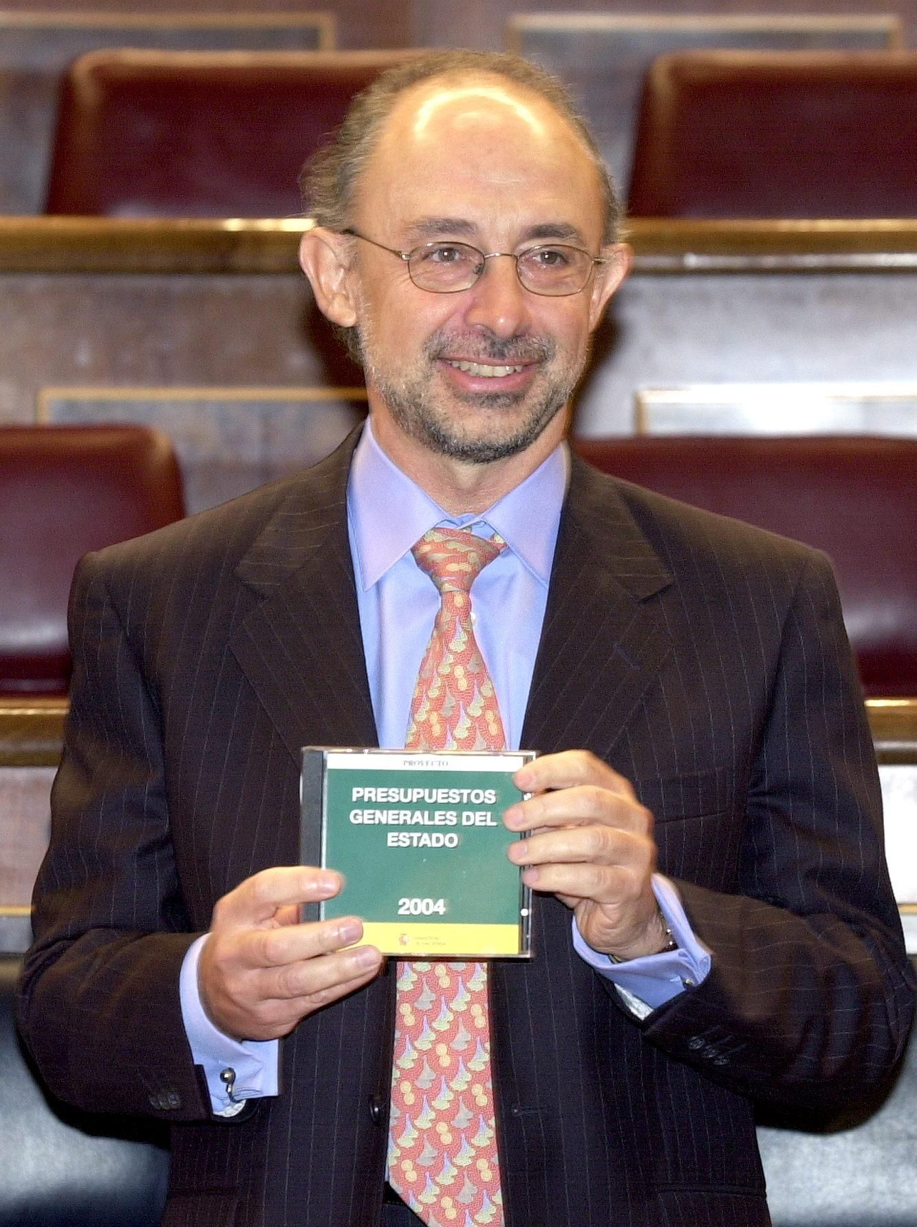 El ministro de Hacienda, Cristóbal Montoro, muestra en el hemiciclo del Congreso un CD-Rom con el proyecto de ley de Presupuestos Generales del Estado para 2004